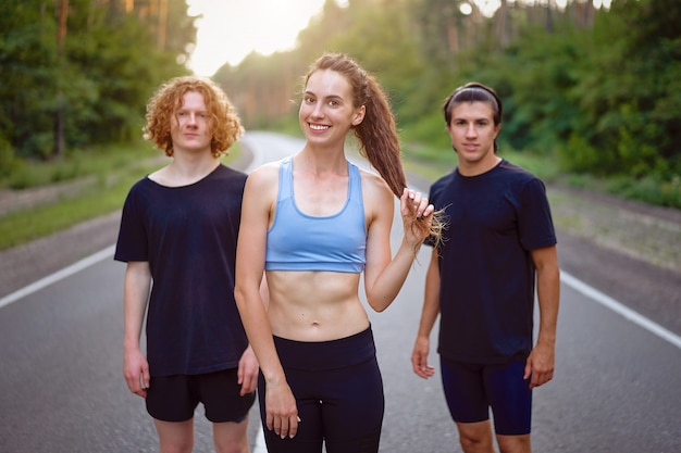 Groupe de trois personnes debout en plein air