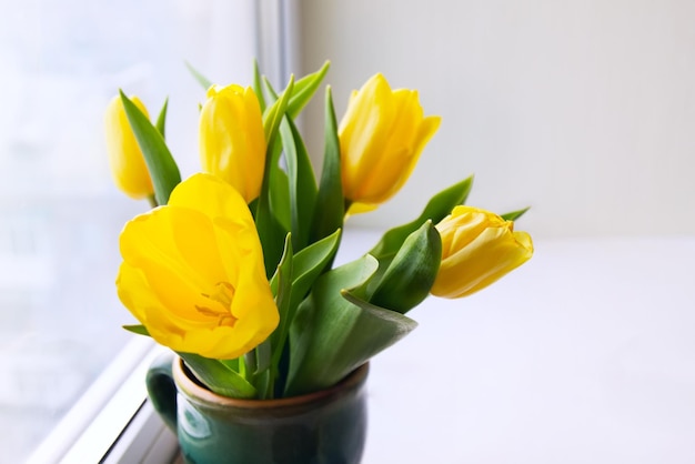 Photo groupe de tulipes jaunes sur une fenêtre