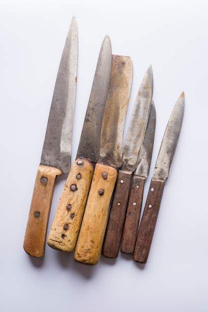 Groupe de vieux couteaux en bois sur fond blanc