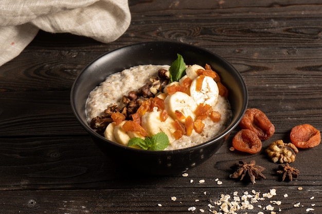 Gruau aux abricots secs, banane et noix, cuit au lait et décoré de girolles à la menthe.