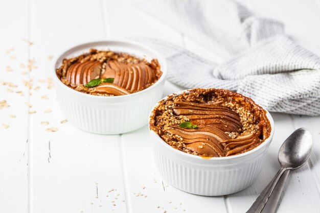 Gruau cuit au four avec poire et cannelle sur fond blanc.