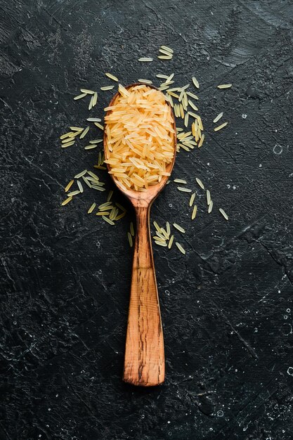 Gruau de riz dans une cuillère en bois sur fond de pierre Nourriture saine