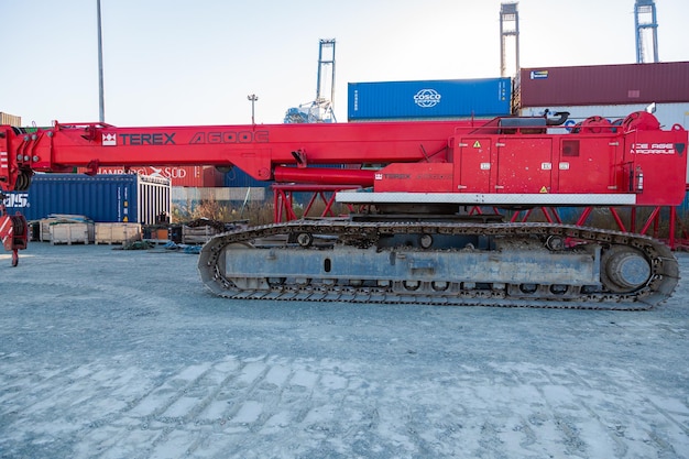 Grue sur chenilles lourde avec crochet abaissé au sol et se dresse sur le territoire d'un terminal à conteneurs