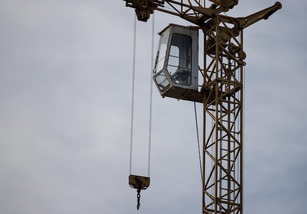 Grue de construction avec une cabine contre le ciel