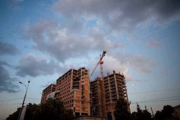 Grue de construction sur le chantier. Grue à tour sur le chantier au coucher du soleil