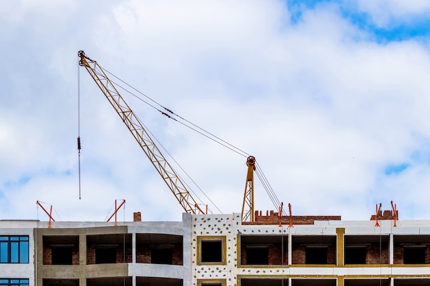 Grue de construction sur un fond de ciel près du nouveau bâtiment