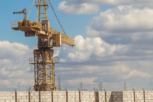 Grue de construction sur le fond du ciel et des nuages blancs