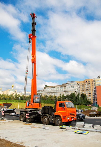 Grue mobile sur chantier de construction dans la ville sur fond de ciel Reconstruction de la chaussée de la rue