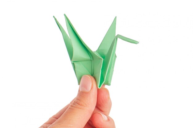 Grue en origami sur surface blanche