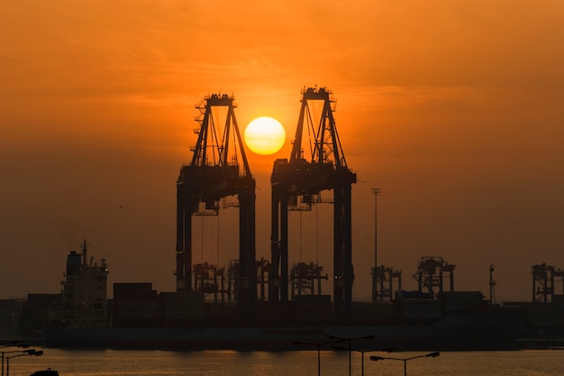 Grue à portique avec soleil levant. Matin au port.