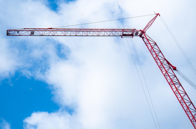 Grue pour la construction Arrière-plan avec ciel lumineux nuages blancs Outils pour la construction d'immeubles de grande hauteur