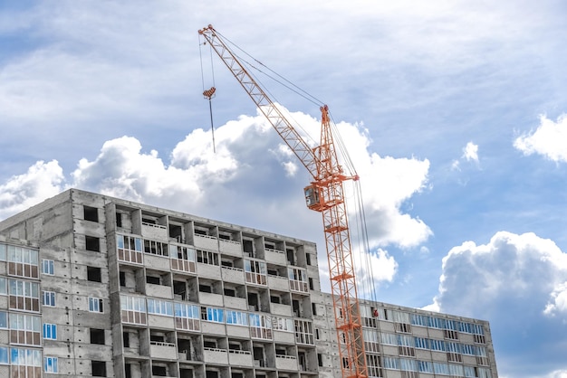 Grue près du bâtiment sur fond de ciel nuageux