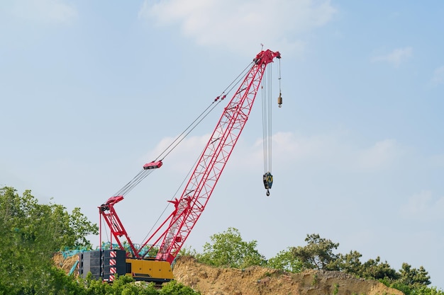 Photo une grue rouge est utilisée pour soulever un gros tas de terre