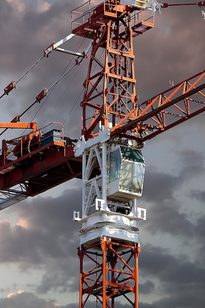 Grue rouge industrielle, fond de coucher de soleil, construction et travaux