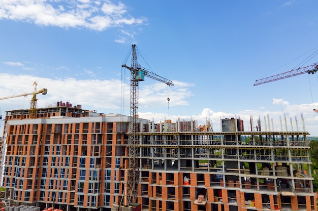 Grue à tour à haut bâtiment résidentiel en béton en construction. Concept de développement immobilier.