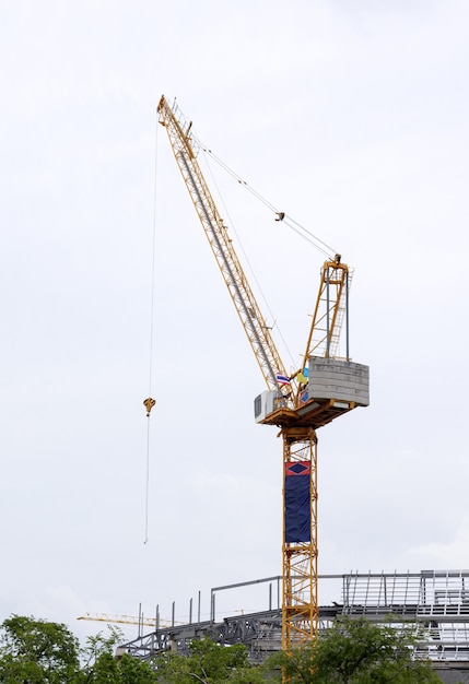 Photo grue à tour haute dans le chantier de construction du grand bâtiment gouvernemental dans la zone urbaine.