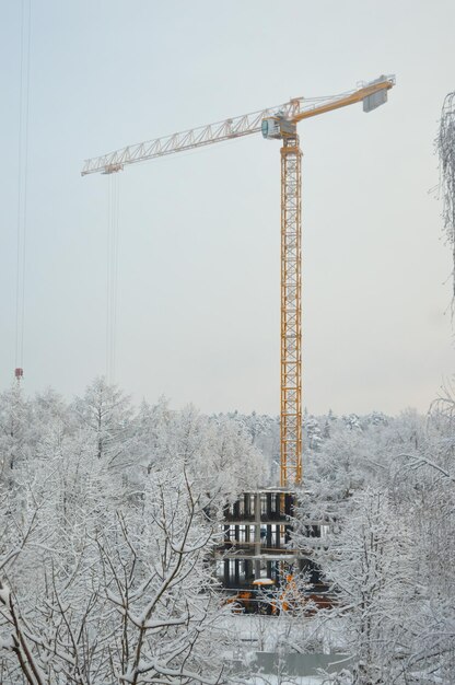 grue à tour de travail sur un chantier de construction, hiver enneigé.