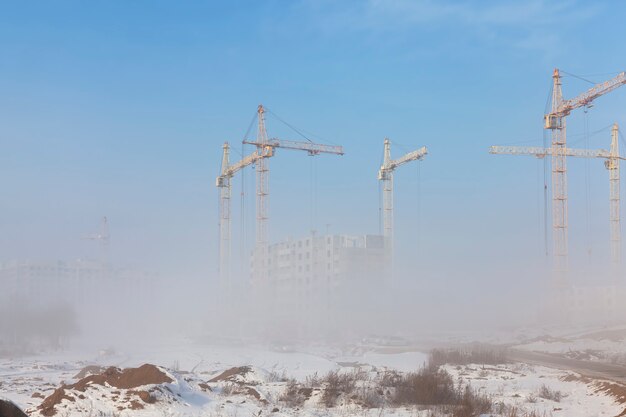 Grues de construction sur un chantier de construction en hiver