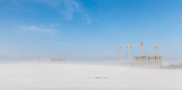 Grues de construction sur un chantier de construction en hiver