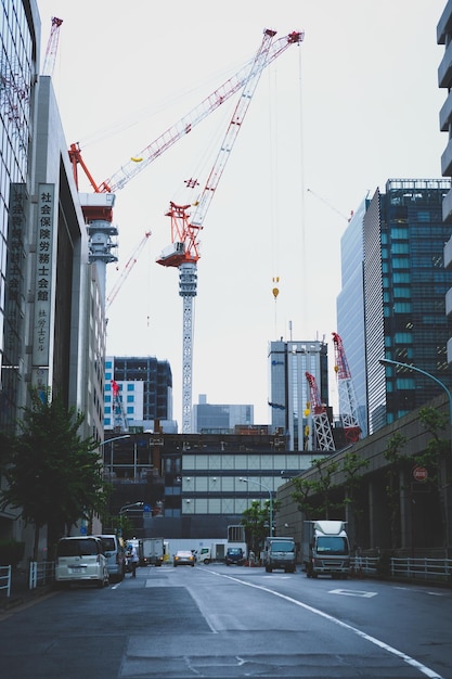 Photo des grues près des bâtiments contre le ciel de la ville