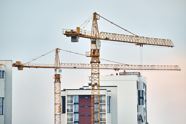 Grues à tour sur le chantier de construction d'immeubles résidentiels élevés. Développement immobilier.