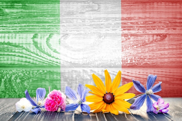 Photo grunge drapeau de l'italie avec des fleurs sauvages wood texture background pour la conception et le texte