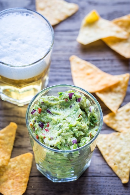 Photo guacamole aux chips de tortilla et verre de bière