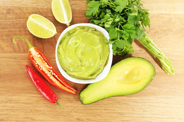 Guacamole frais dans un bol sur une table en bois