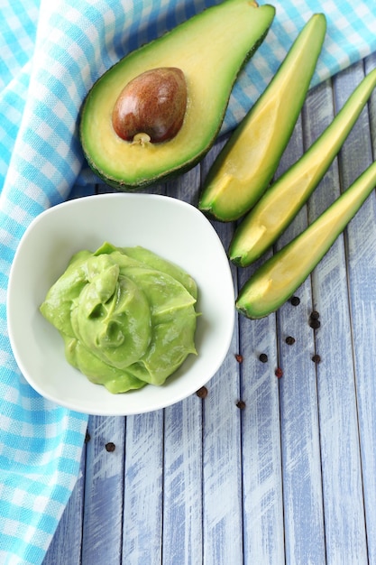 Guacamole frais dans un bol sur une table en bois