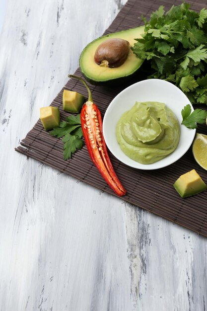 Photo guacamole frais dans un bol sur une table en bois