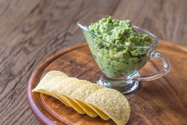 Guacamole avec des frites sur la planche de bois