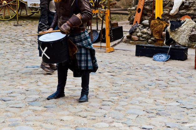 Un guerrier guerrier écossais musicien en costume traditionnel avec une jupe bat le tambour