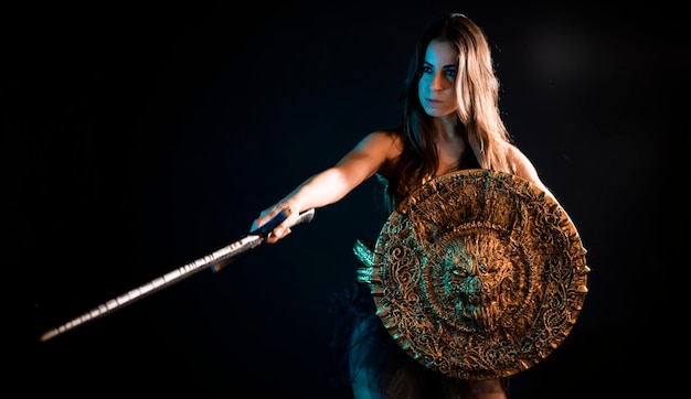 Photo guerrier médiéval, valkyrie, femme avec un manteau de fer d'armure dorée et une grande épée de guerrier