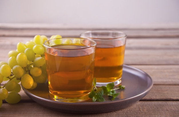 Gug et verres de jus de raisin sur la vieille table en bois