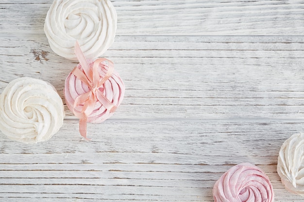 Guimauve rose et blanche douce maison - zéphyr sur une table en bois clair.