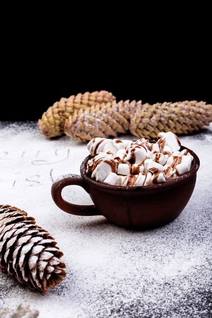 Guimauve sucrée de Noël avec du chocolat dans une tasse brune