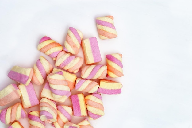 Guimauves douces de couleur rose et jaune sur fond blanc avec espace de copie Aliments sucrés