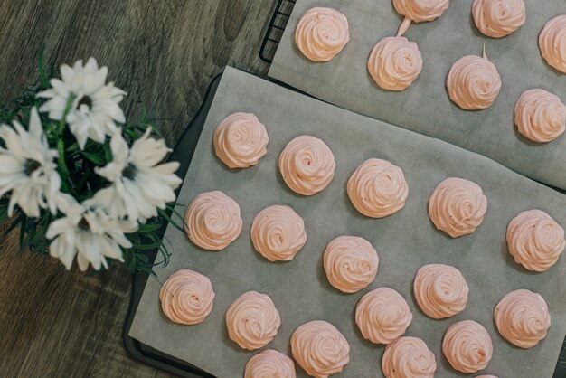 Guimauves roses faites maison sur fond de papier sulfurisé dans la cuisine.