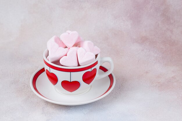 guimauves roses en forme de coeur dans une tasse