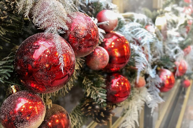 Guirlande décorative de Noël avec des boules rouges et des brindilles de sapin