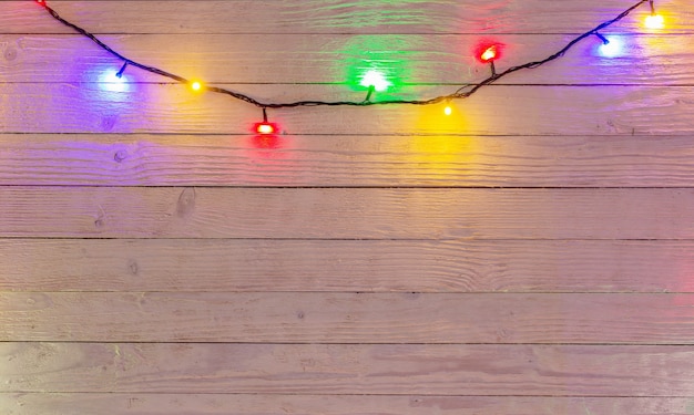 Guirlande électrique avec ampoules multicolores sur une surface en bois, lumières de Noël