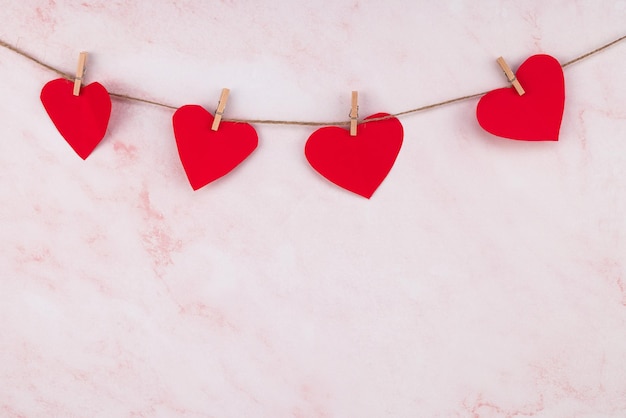 Photo guirlande en forme de coeur rouge sur fond de mur rose guirlande saint valentin
