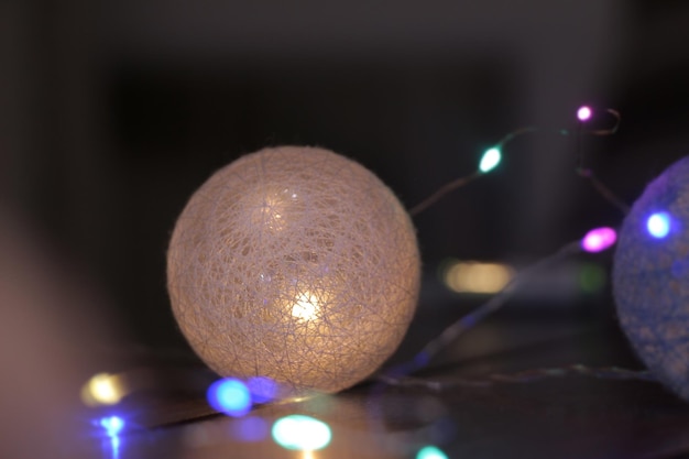Guirlande lumineuse à paillettes brillantes dans les boules d'osier sombres magnifique décor à la maison Place pour votre texte