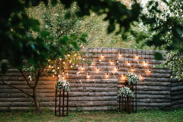 Guirlande murale en bois décorée d'ampoules lumineuses et de lampes électriques décorées de fleurs Décoration florale de mariage originale Zone de salon de réception de mariage