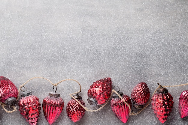 Guirlande de Noël avec boule rouge et fond gris.