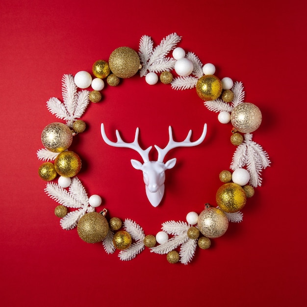 Guirlande de Noël avec des branches de pin blanc, renne blanc et décoration de boule