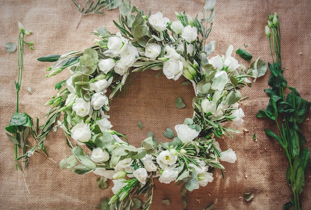 Guirlande de roses blanches sur fond de jute. Décoré