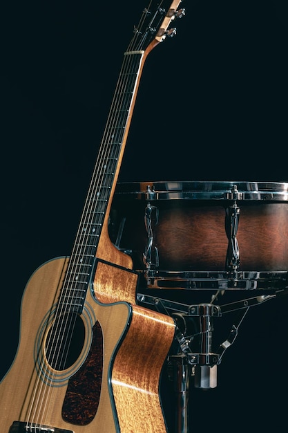 Guitare acoustique et caisse claire sur fond noir isolé