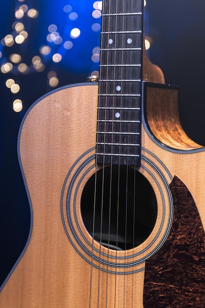 Guitare acoustique gros plan sur un fond sombre avec des lumières bokeh