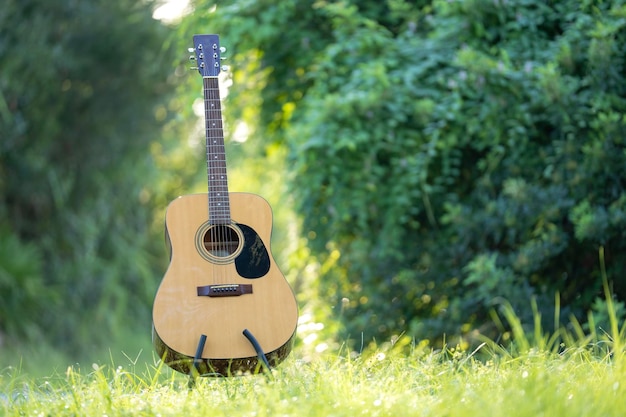 Guitare acoustique en plein air sur un fond vert Concept de musique calme